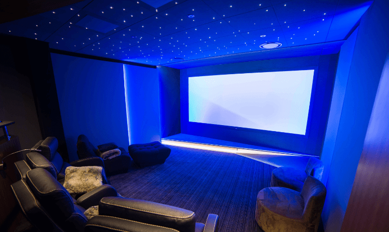 Salle de cinema privée noire avec 5 places et un plafond étoilé bleu par Ocinema