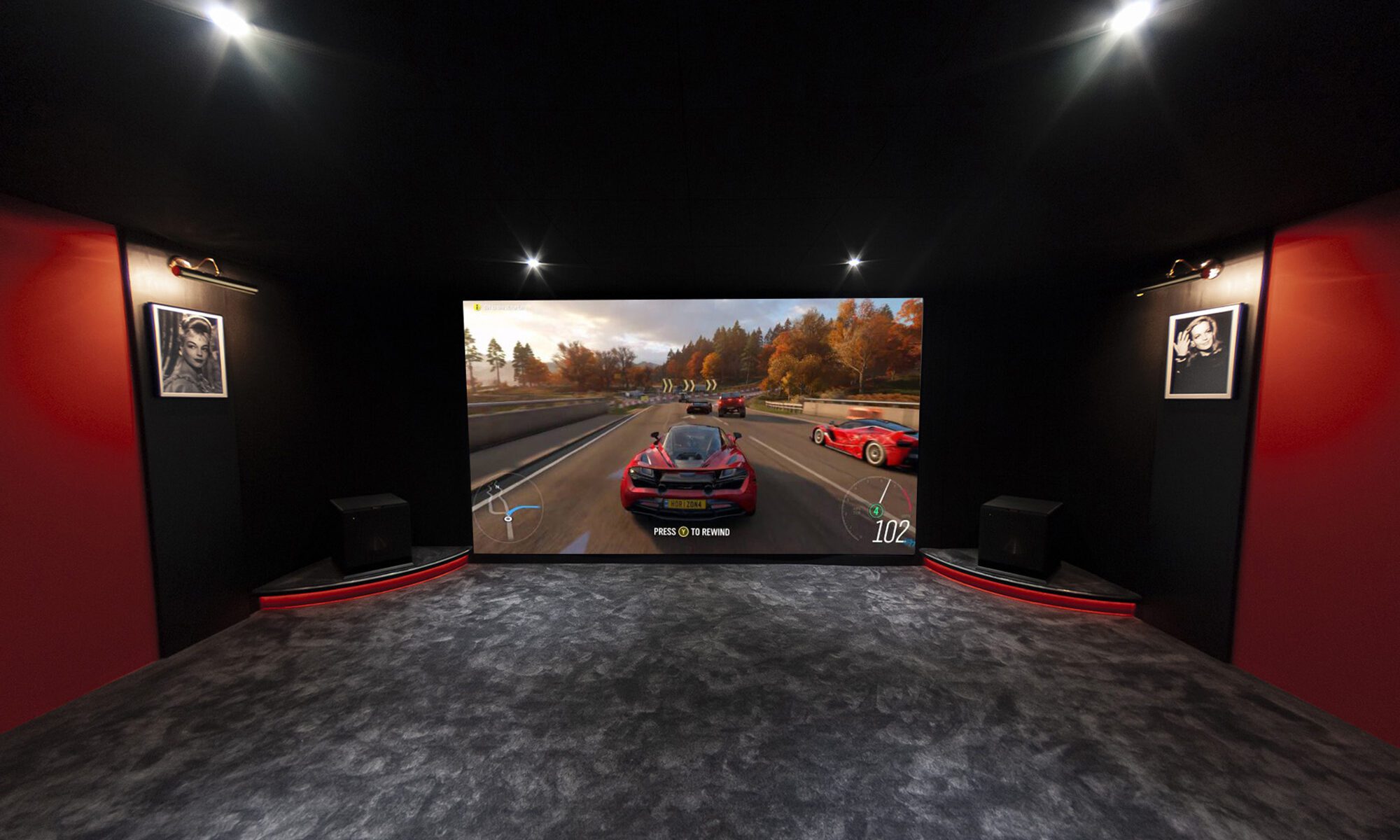 Salle de cinéma aménagée à la maison à Bayonne avec moquette grise, des murs rouges et 4 spots de lumière