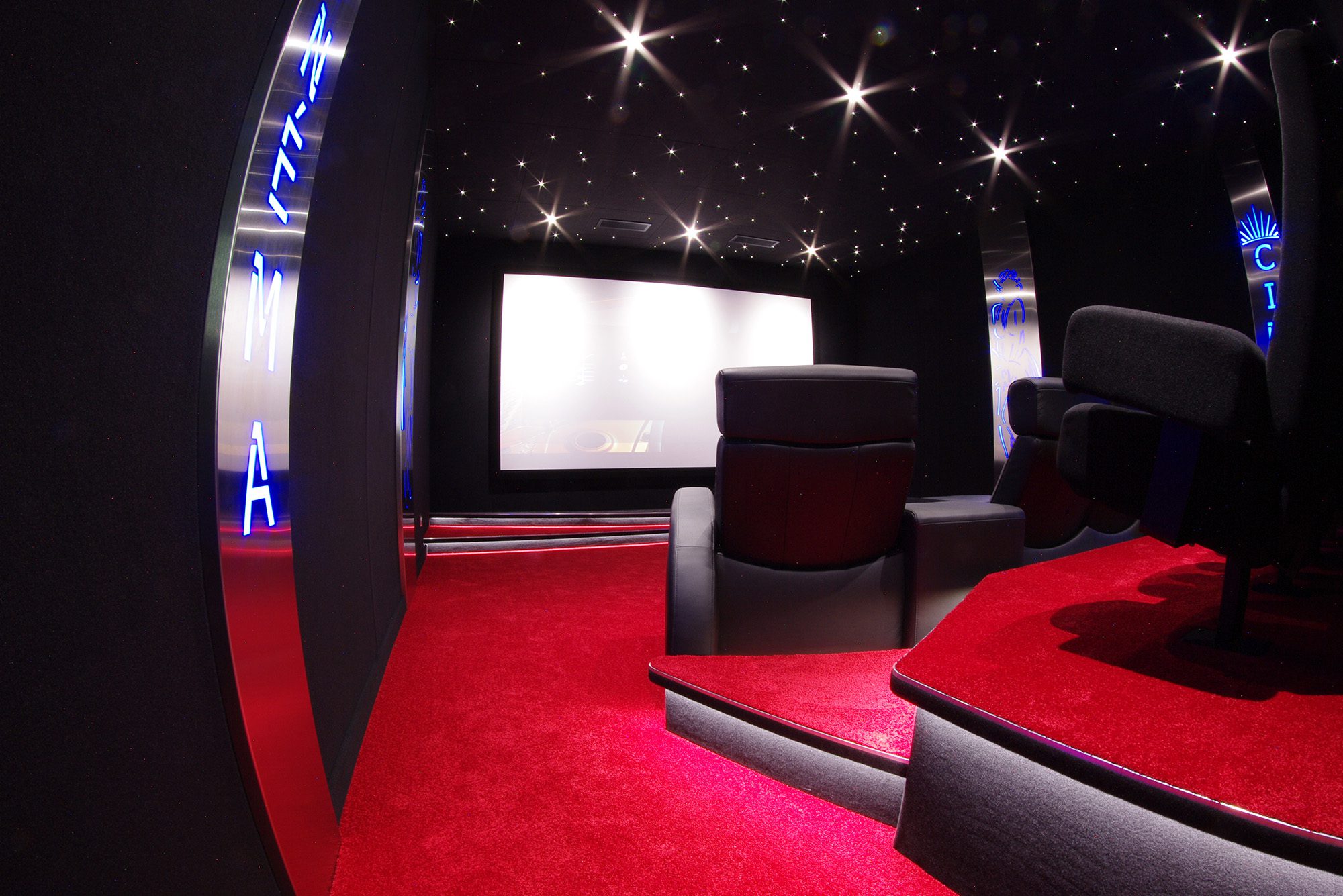 Salle de cinéma privée 33m2, 11 fauteuils et poufs en cuir noir, avant-scène, ciel étoilé, spots, panneaux décors métalliques à Versailles