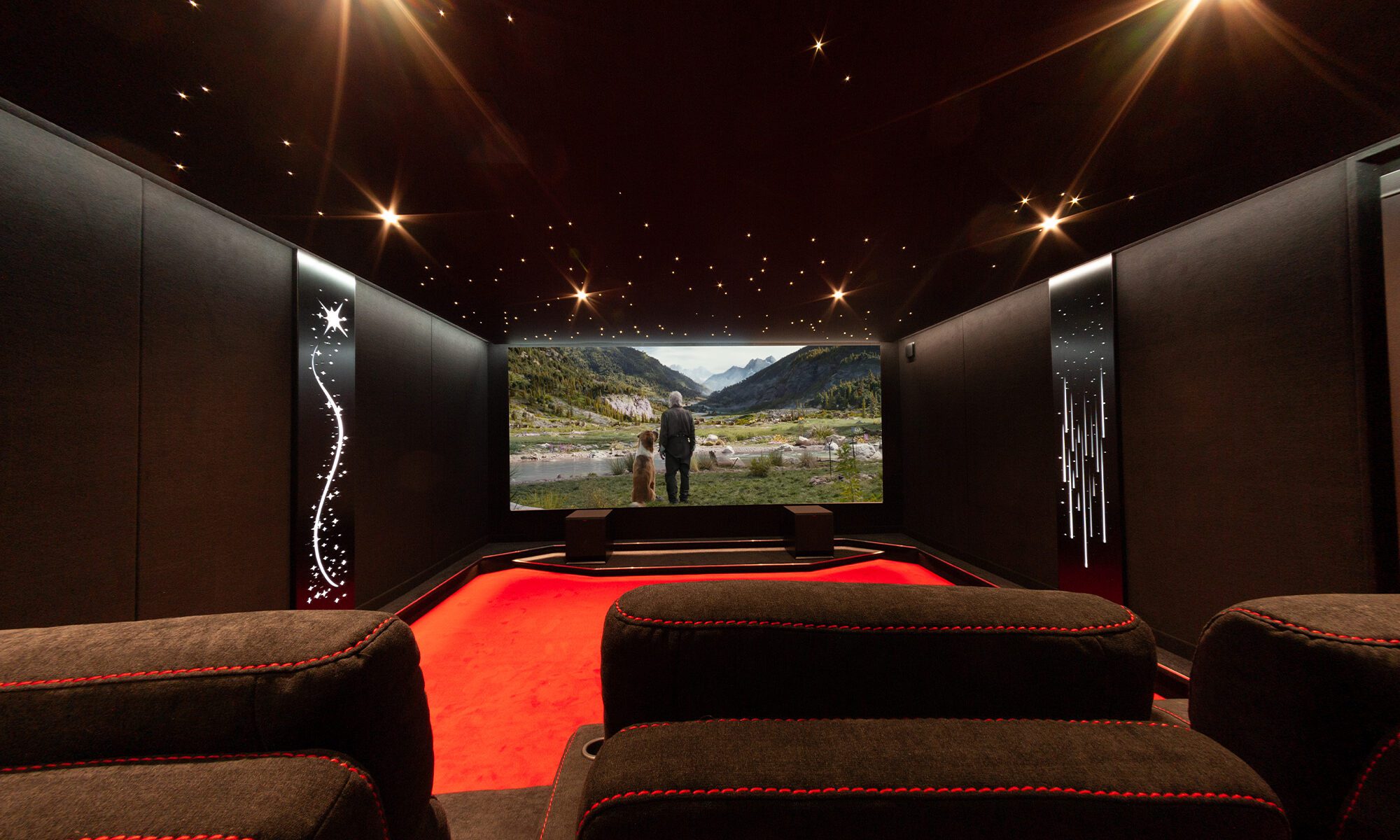 Salle de cinéma 7 places noire 29m2, plafond étoilé, panneaux acoustiques lumineux noir et moquette rouge à Vannes