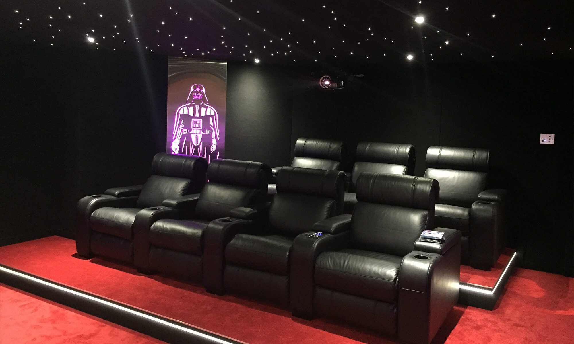 Installation Salle de cinéma privée 35m2 avec 7 fauteuils en cuir noir, ciel étoilé, spots, panneaux décor métallique rétroéclairé à Fribourg