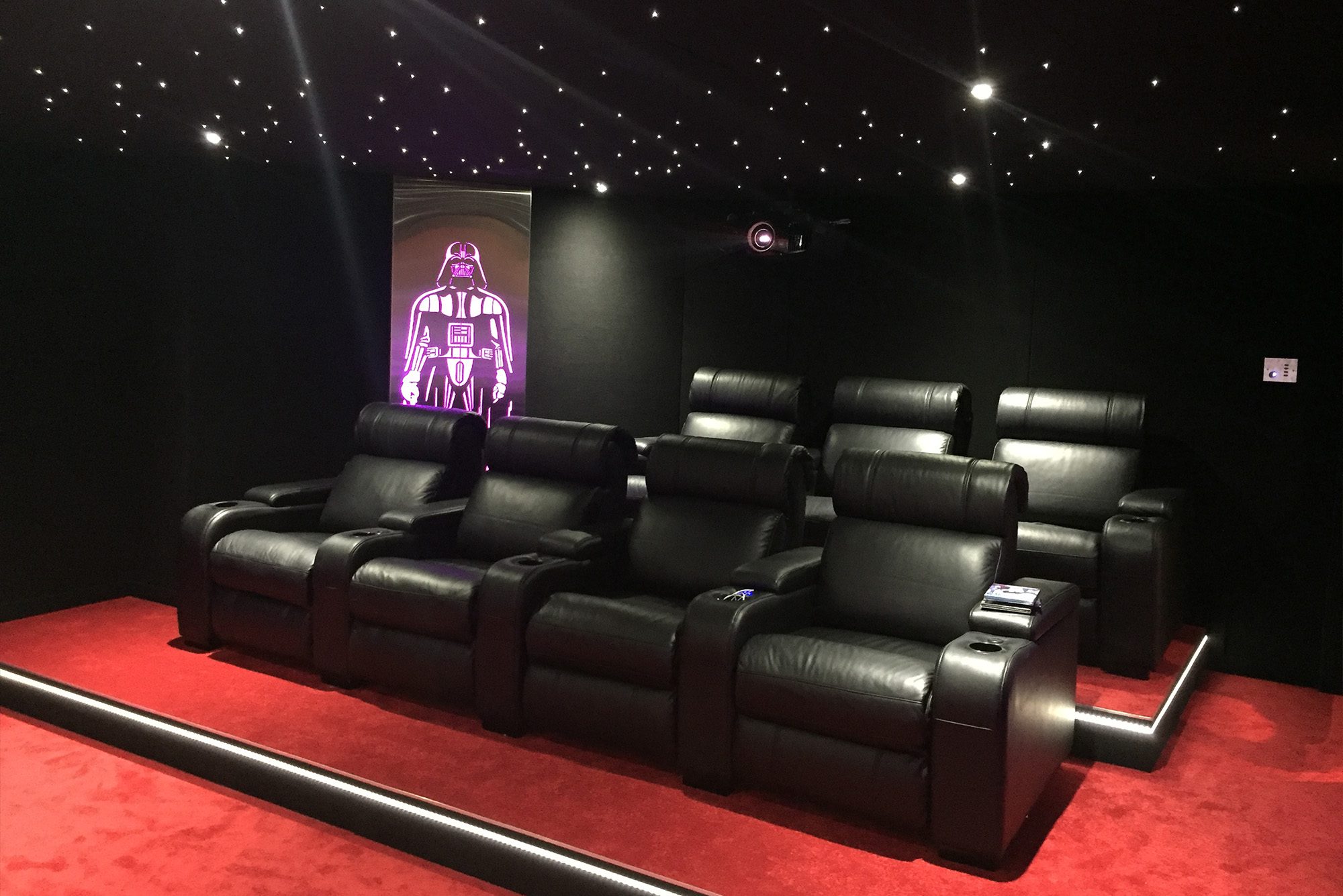 Installation Salle de cinéma privée 35m2 avec 7 fauteuils en cuir noir, ciel étoilé, spots, panneaux décor métallique rétroéclairé à Fribourg