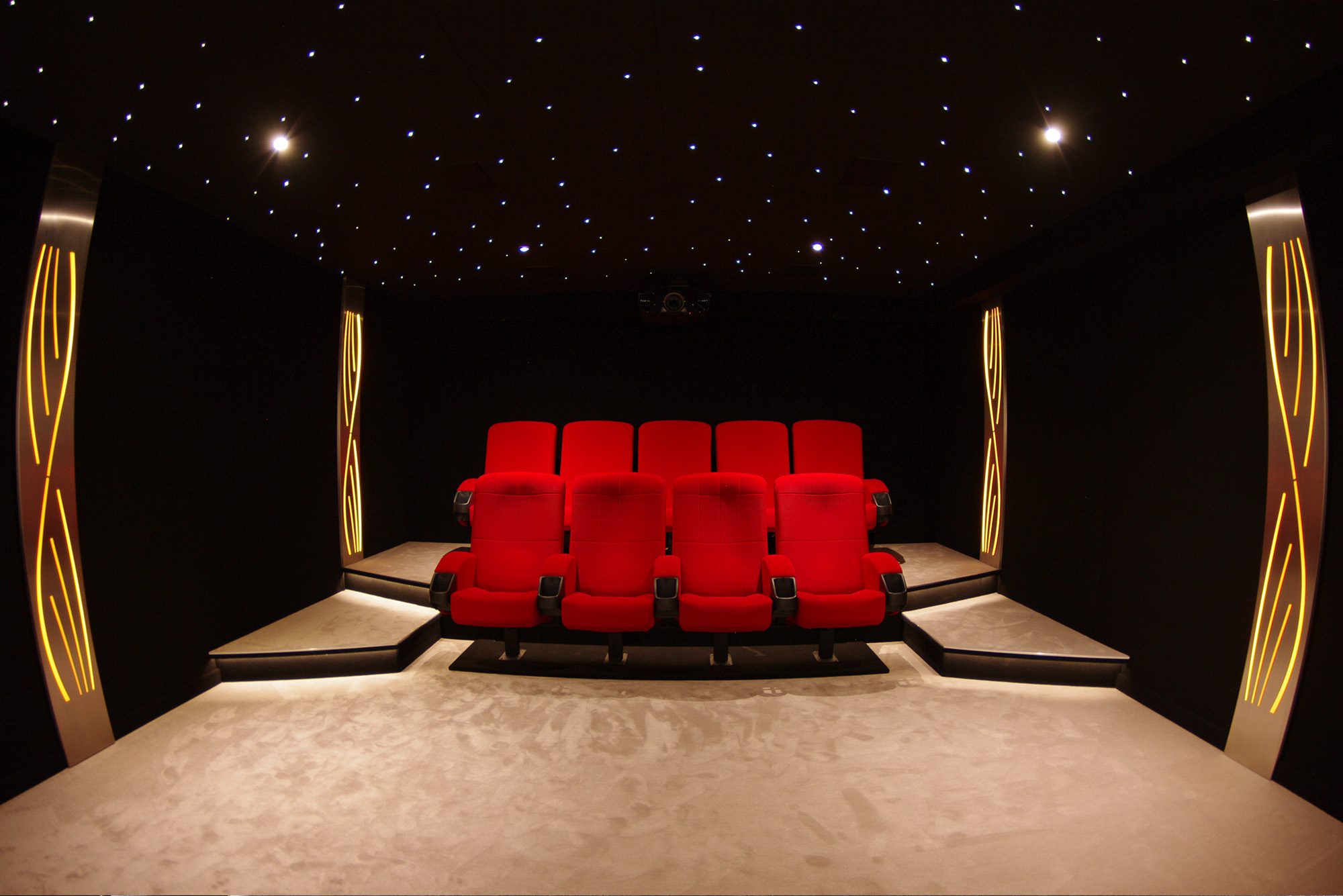 Salle de cinéma privée 35m2 avec 9 fauteuils en tissu rouge, ciel étoilé, spots, panneaux décor métallique personnalisée à Nice