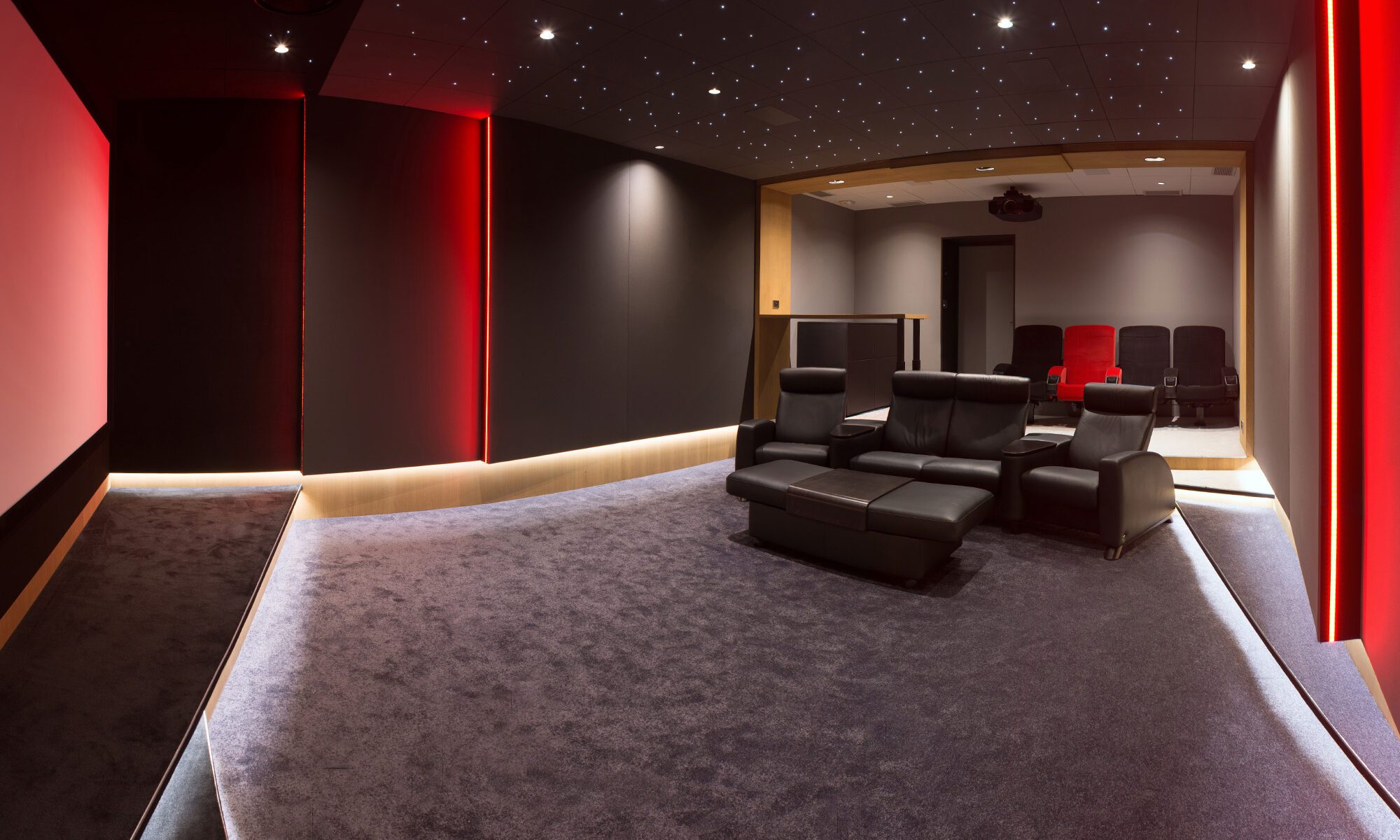 Salle de cinéma privée 35m2 avec 7 fauteuils en cuir noir dont un rouge, arche et meubles en chêne sur-mesure, ciel étoilé, spots, rubans led, moquette grise à Péronne