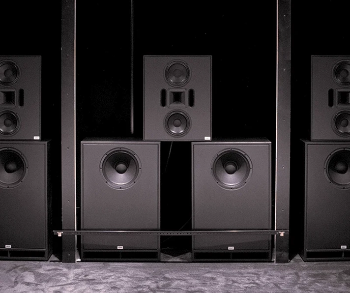 Twee luidsprekers en een subwoofer op een donkere achtergrond