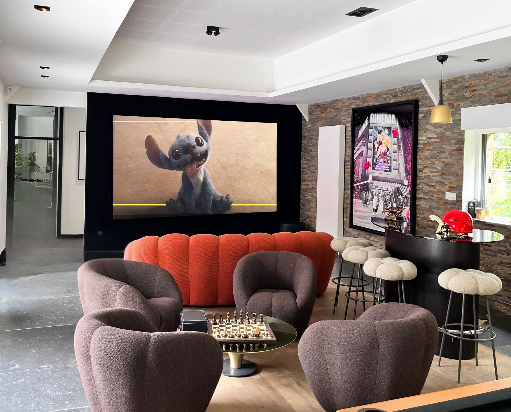 Billard au premier plan face à un écran de projection et un salon dans un espace de loisirs