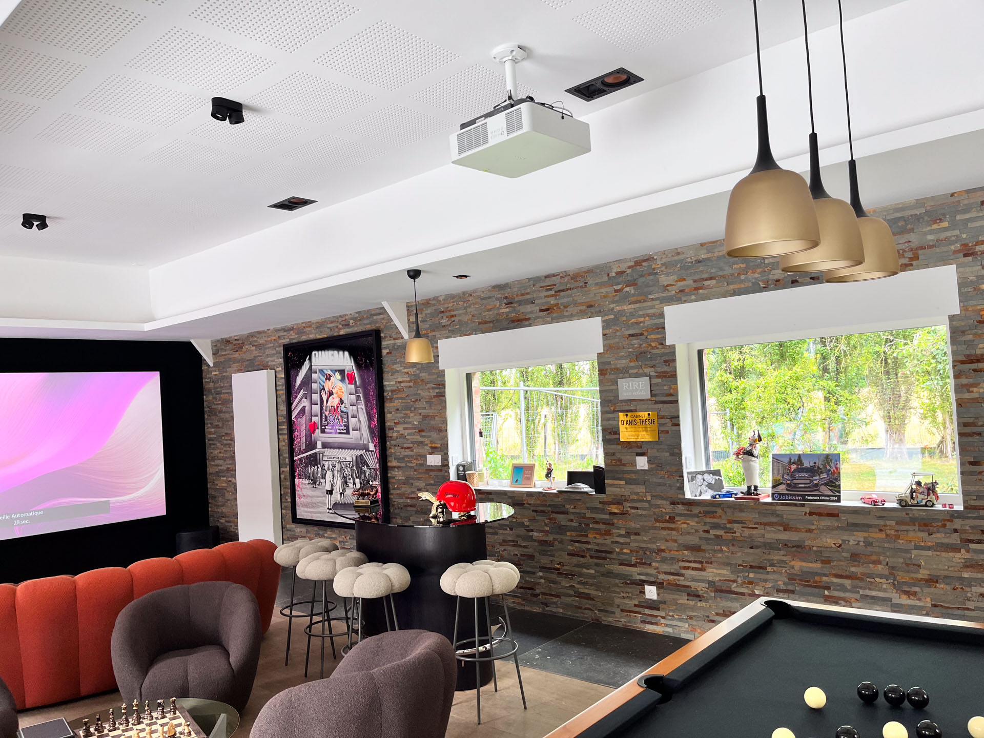 Vidéoprojecteur Sony au plafond, enceintes JBL, bar et billard dans un espace de loisirs