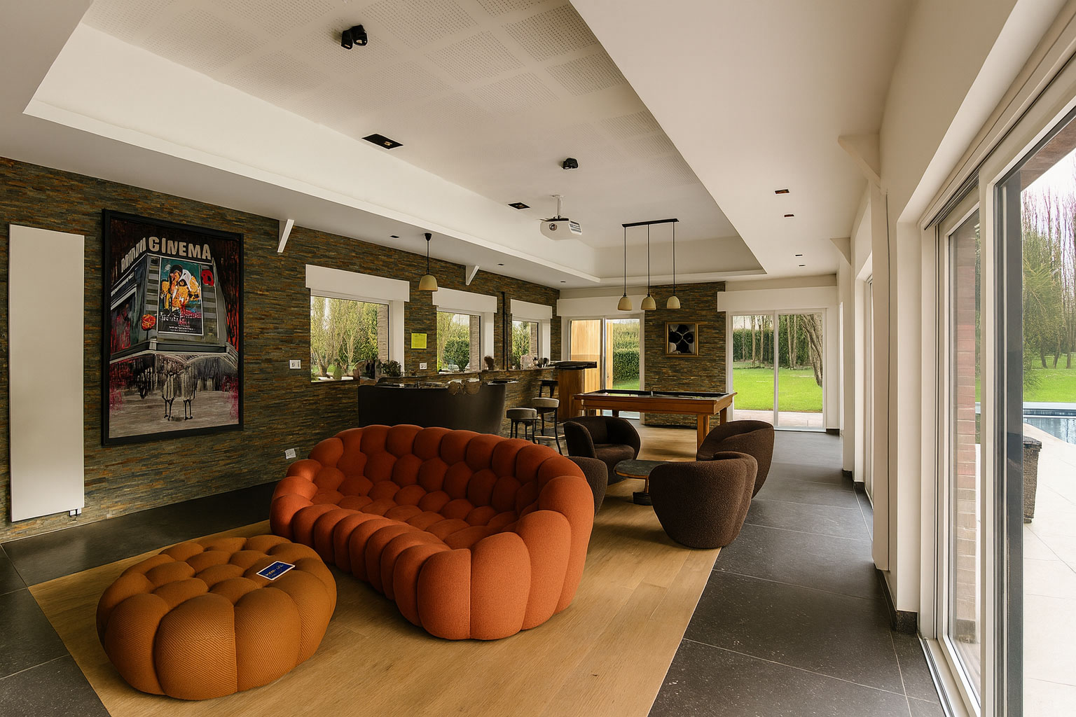 Salon avec canapé orange, fauteuils lounge, billard et accès au jardin près de Lille