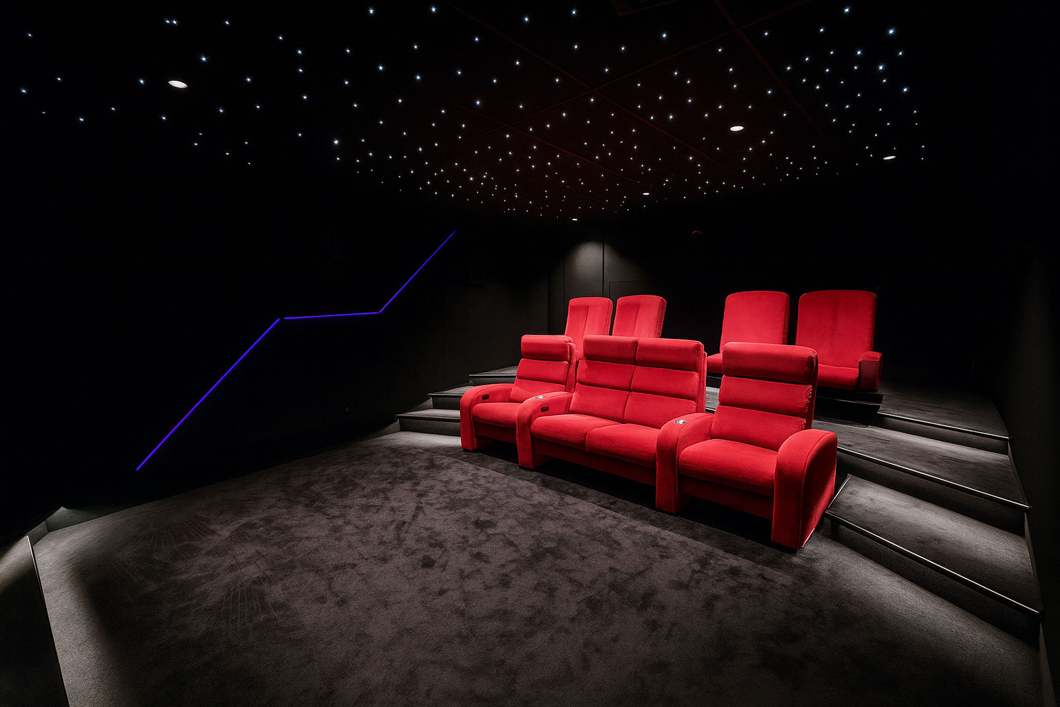 Fauteuils relax en velours rouge dans une salle cinéma privée secteur Megève