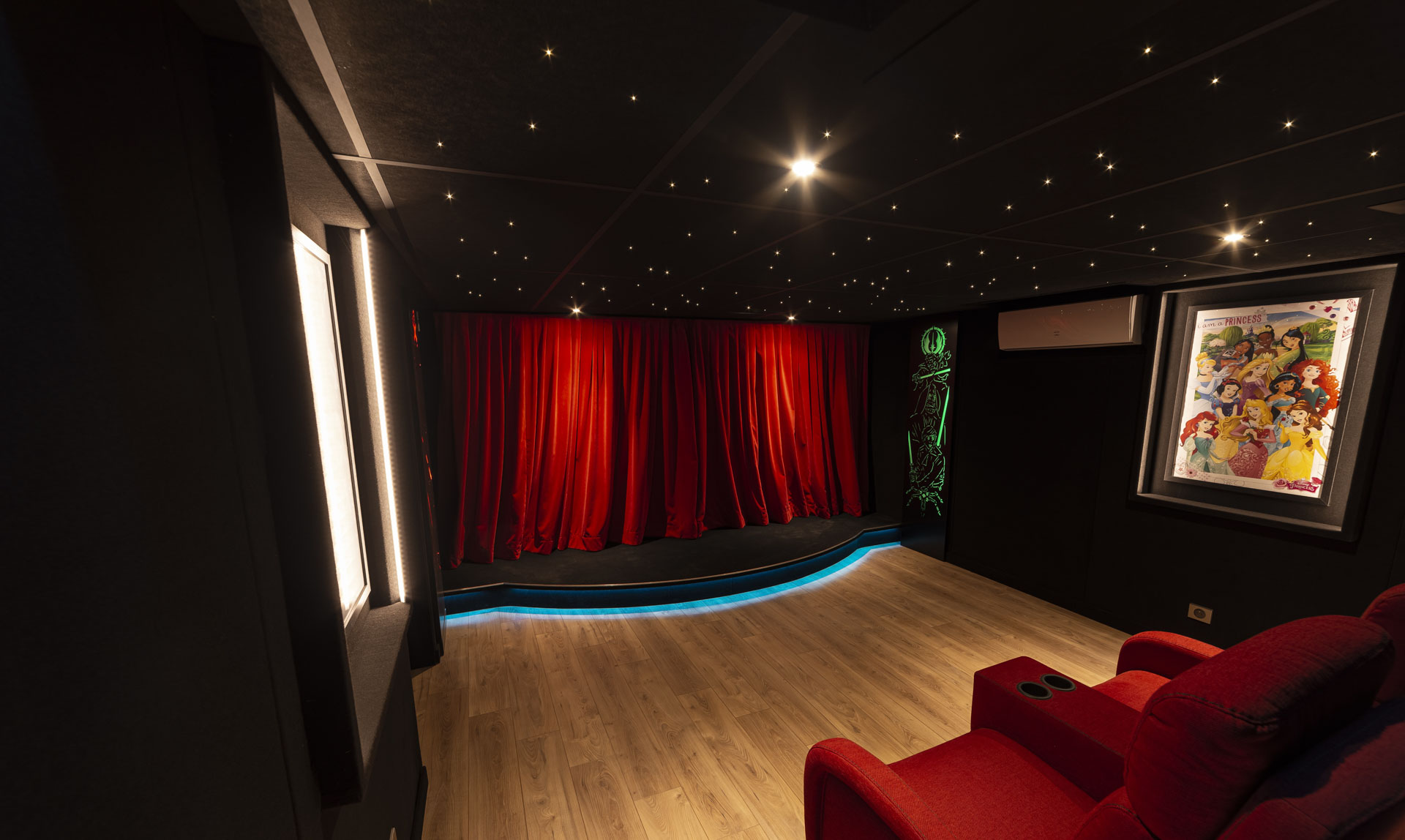 Plafond étoilé, affiches rétroéclairées et panneaux graphiques dans un cinéma privé