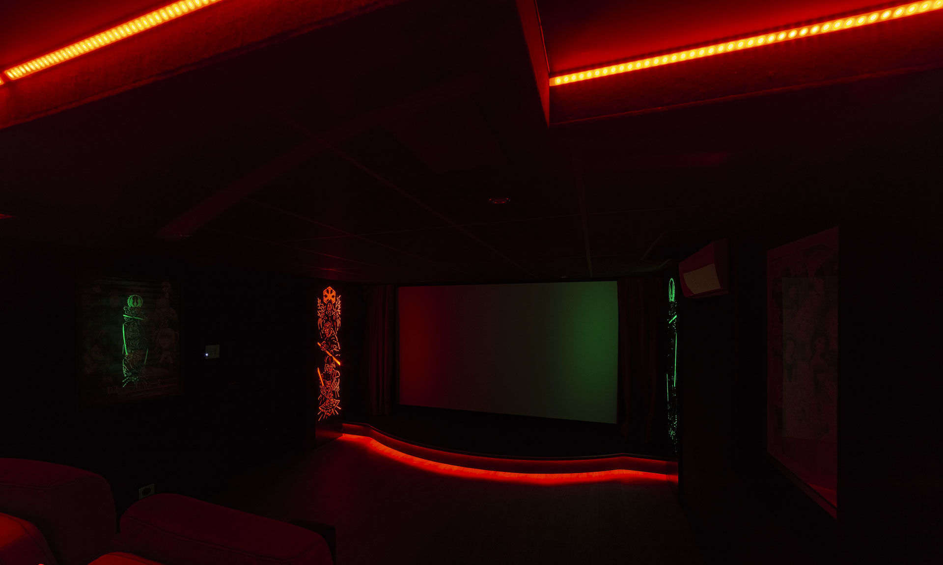 Écran de projection avec éclairage LED rouge et vert dans une salle de cinéma privée
