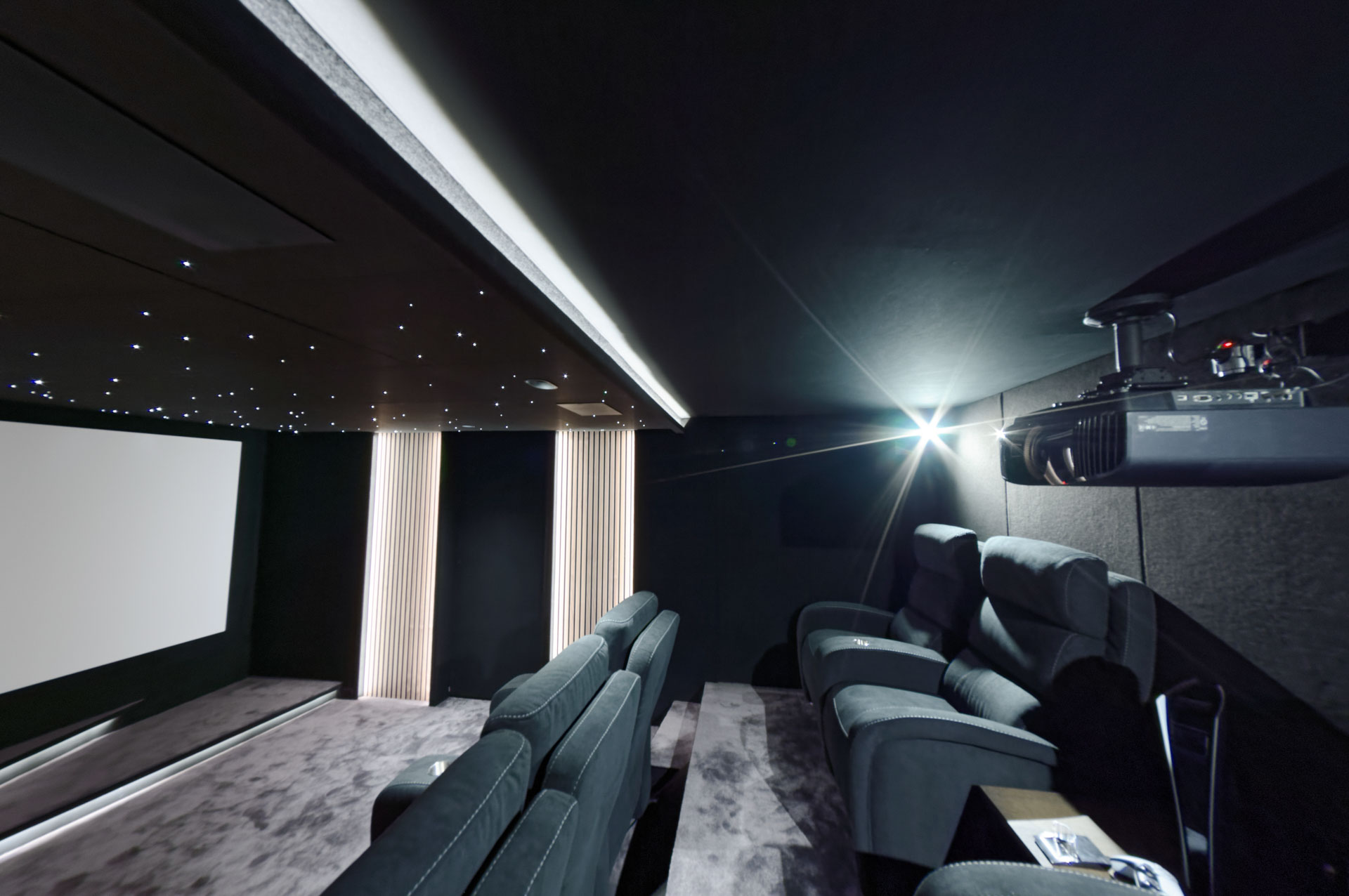 Vaste plafond étoilé et vidéoprojecteur Sony 4K dans une salle de cinéma privée