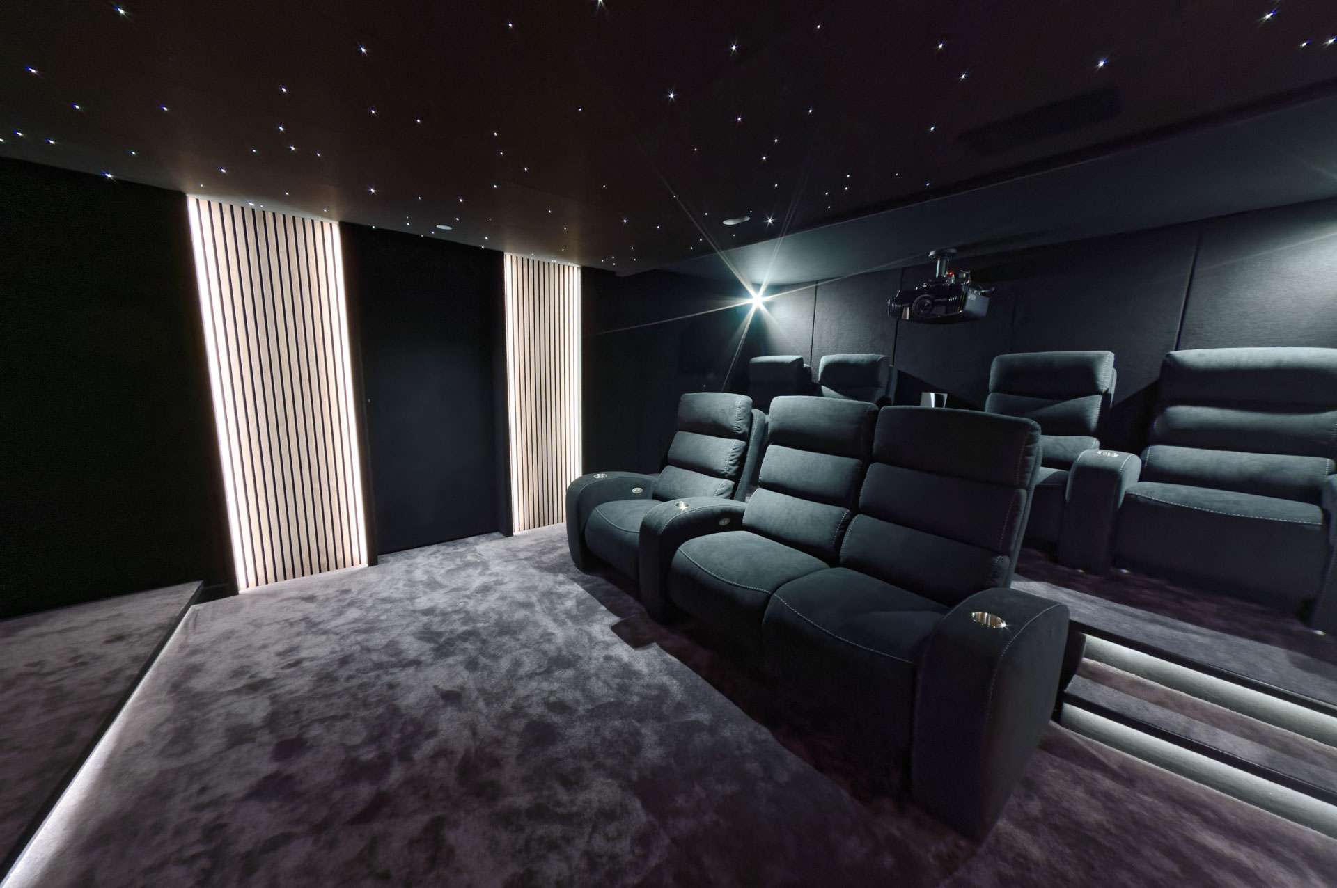 Parois noires dissimulant le traitement acoustique ÉPIDAURE® dans un cinéma privé